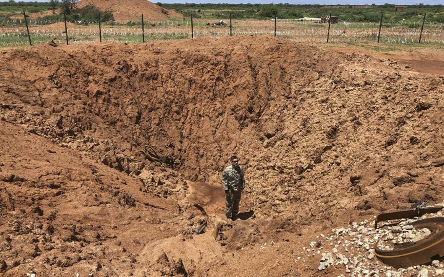 A New Jersey Army National Guard soldier stands in a crater created by a vehicle-borne explosive at Baledogle Military Airfield, Somalia, Sept. 30, 2019.